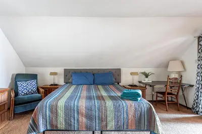 a bedroom with a bed and a desk and a chair at Boardwalk Chalet Lakefront Fire Pit Pet Frie in Tobyhanna