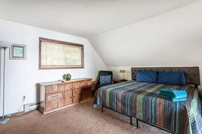 a bedroom with a bed and a dresser and a window at Boardwalk Chalet Lakefront Fire Pit Pet Frie in Tobyhanna