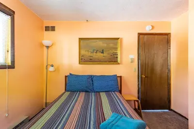a bedroom with a bed and a painting on the wall at Boardwalk Chalet Lakefront Fire Pit Pet Frie in Tobyhanna