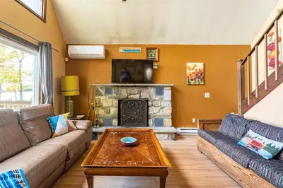 a living room with a couch and a fireplace at Boardwalk Chalet Lakefront Fire Pit Pet Frie in Tobyhanna