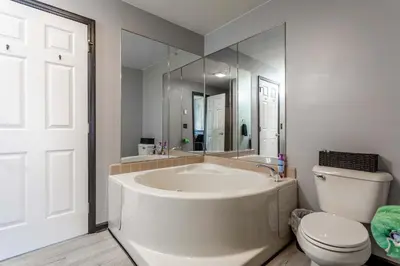 a white bathroom with a tub and a toilet at Hot Tub Game Room Fenced Yard Dog Friendly in Albrightsville