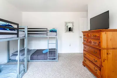a bedroom with bunk beds and a tv and a dresser at My Blue Haven Game Area 4 BDR Pet Friendly in Albrightsville