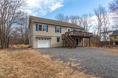 a large house with a garage and a deck at My Blue Haven Game Area 4 BDR Pet Friendly in Albrightsville