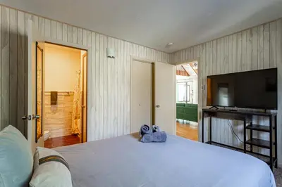 a bedroom with a large bed and a flat screen tv at Game Room Fire Pit Dog Friendly in Tobyhanna