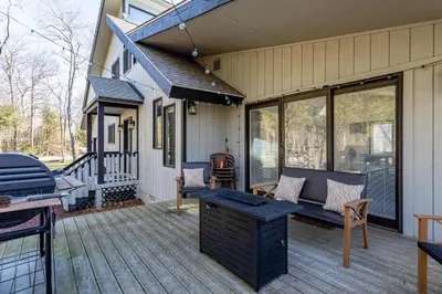 a porch with a bench and a grill on a house at Game Room Fire Pit Dog Friendly in Tobyhanna