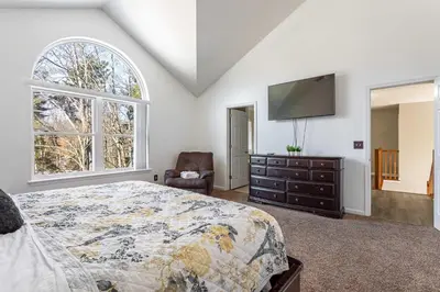 a bedroom with a bed and a flat screen tv at Lakeside Haven 5 BDR Fire Pit Pet Friendly in Tobyhanna