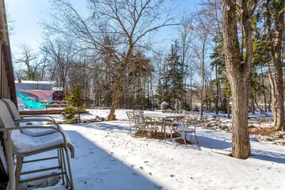 a table and chairs in the snow on a house at Lakeside Haven 5 BDR Fire Pit Pet Friendly in Tobyhanna