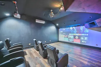 a room with a bowling alley with chairs and a screen at Heated Indoor Private Pool Stream Front Game Room in Cresco