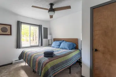 a bedroom with a bed and a window at Lakeside Chalet 3BR Fire Pit Pet Friendly in Tobyhanna
