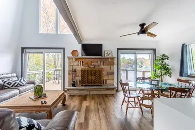 a living room with a couch and a table at Lakeside Chalet 3BR Fire Pit Pet Friendly in Tobyhanna