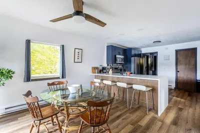 a kitchen and dining room with a glass table and chairs at Lakeside Chalet 3BR Fire Pit Pet Friendly in Tobyhanna