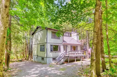 a small house in the middle of the forest at 4BDR Hot Tub Game Room in Lake Ariel