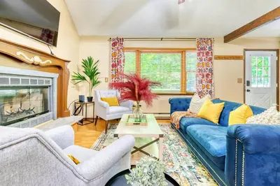a living room with blue couches and a fireplace at 4BDR Hot Tub Game Room in Lake Ariel