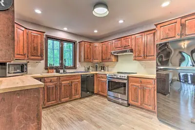 a kitchen with wooden cabinets and stainless steel appliances at Hot Tub Secluded Fire Pit Hammock in Stroudsburg