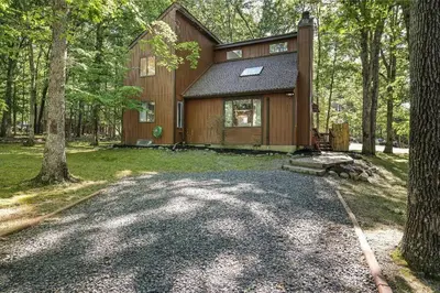 a home in the woods with a gravel driveway at Cozy 3 BR Game Area Fire Pit in East Stroudsburg