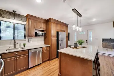 a large kitchen with wooden cabinets and a counter top at Cozy 3 BR Game Area Fire Pit in East Stroudsburg