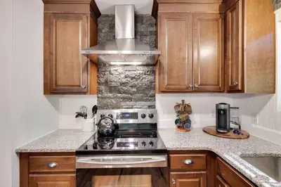 a kitchen with wooden cabinets and a stove top oven at Cozy 3 BR Game Area Fire Pit in East Stroudsburg
