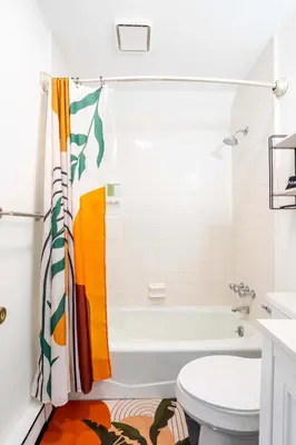 a bathroom with a tub and a toilet at Cozy 3BD 2Minutes from Beach in East Stroudsburg