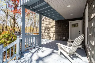 a porch with a white rocking chair on a house at Cozy 3BD 2Minutes from Beach in East Stroudsburg