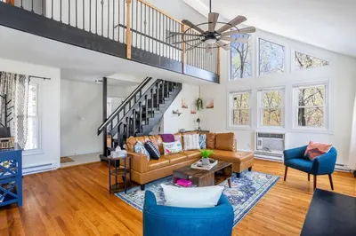 a living room with a couch and a staircase at Cozy 3BD 2Minutes from Beach in East Stroudsburg