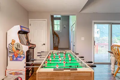a room with a foosball table and a video game at Cozy 3Br Fire Pit Hammock 2 Minutes to Beach in East Stroudsburg