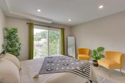 a bedroom with a bed and two chairs and a window at Spacious 6 Bedroom Home with NYC Access & Parking! in Newark