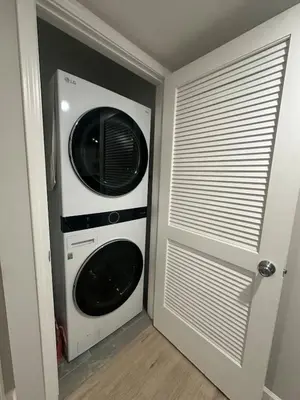 a microwave and a washer and dryer in a room at Spacious 6 Bedroom Home with NYC Access & Parking! in Newark