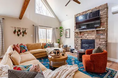 a living room with a couch and a fireplace at The Buckhorn Chalet Hot Tub Arcades 6 Bedroom Fire Place in Albrightsville