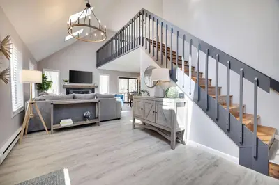 a living room with a staircase and a couch at Blue Wolf Retreat Pool Table Cozy BBQ in Albrightsville