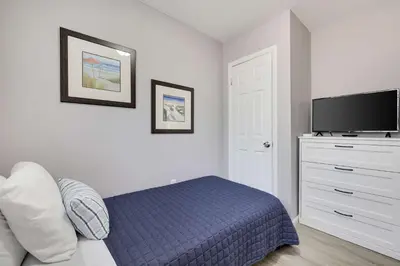 a bedroom with a bed and a flat screen tv at Blue Wolf Retreat Pool Table Cozy BBQ in Albrightsville