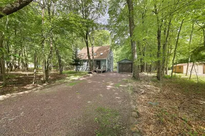 an empty driveway to a house in the woods at Blue Wolf Retreat Pool Table Cozy BBQ in Albrightsville