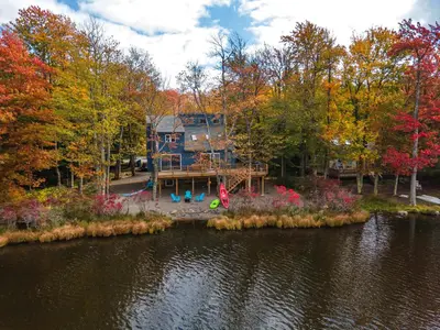 an aerial view of a house next to a lake at Tranquil Shores Waterfront Fire Pit Hammock in Tobyhanna