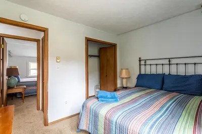 a bedroom with a large bed and a mirror at Tranquil Shores Waterfront Fire Pit Hammock in Tobyhanna