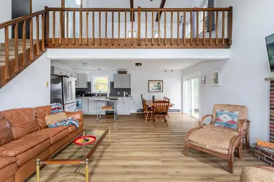 a living room with a couch and a table at Tranquil Shores Waterfront Fire Pit Hammock in Tobyhanna