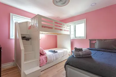 a bedroom with pink walls and a bunk bed at The Woodland Escape Pool Table Fire Pit 4 BD in Tobyhanna