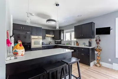 a kitchen with black cabinets and a kitchen island at The Woodland Escape Pool Table Fire Pit 4 BD in Tobyhanna