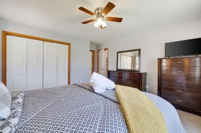 a bedroom with a bed with a ceiling fan at Cedar Cove Retreat Pool BBQ Game Room in Albrightsville