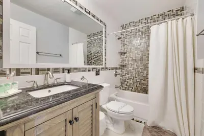 a white bathroom with a sink and a toilet at Cedar Cove Retreat Pool BBQ Game Room in Albrightsville
