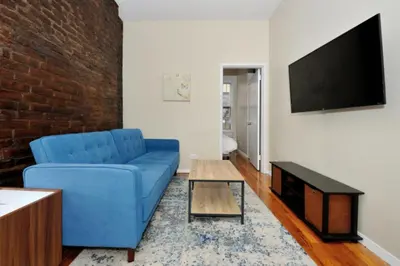 a living room with a blue couch and a tv at Charming 1BR in Murray Hill Kips Bay - Perfect for 2 in New York