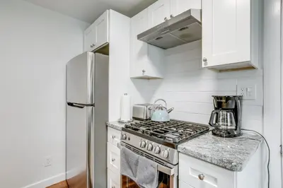 a white kitchen with a stove and a refrigerator at Walkable Dtwn Townhome Near Campus and Palmer Square in Princeton