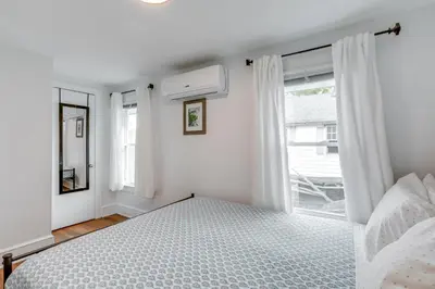 a white bedroom with a bed and a window at Walkable Dtwn Townhome Near Campus and Palmer Square in Princeton