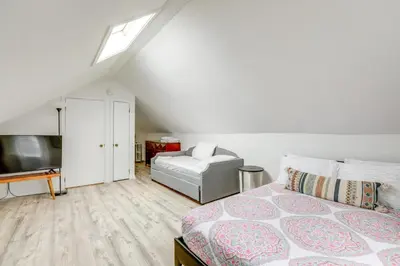 a bedroom with a bed and a couch and a television at Walk to Campus and Palmer Square Dtwn Townhome in Princeton