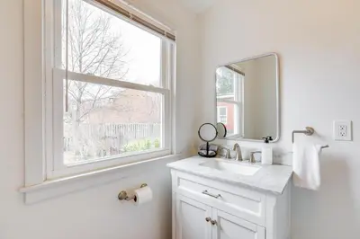a white bathroom with a sink and a window at Walk to Campus and Palmer Square Dtwn Townhome in Princeton