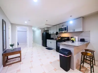 a kitchen with white cabinets and a counter top at Spacious 2BR Apartment in Jersey City - Easy NYC Access in Jersey City
