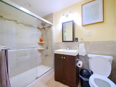 a bathroom with a shower and a toilet and a sink at Spacious 2BR Apartment in Jersey City - Easy NYC Access in Jersey City
