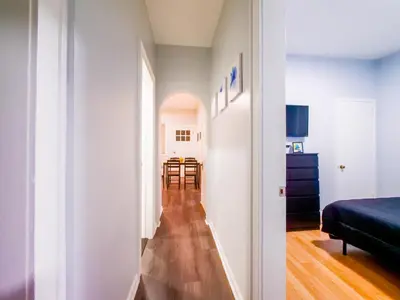 a hallway leading to a room with a bed and a table at NYC Views & Comfort - Modern 2-Bedroom Apartment in Jersey City