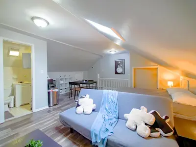 two stuffed animals sitting on a blue couch in a bedroom at Cozy Jersey City Apt near NYC Free Wi-Fi & Great Location in Jersey City