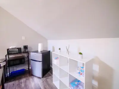 a kitchen with a refrigerator and a white shelf at Cozy Jersey City Apt near NYC Free Wi-Fi & Great Location in Jersey City