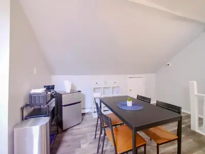 a kitchen with a black table and chairs and a refrigerator at Cozy Jersey City Apt near NYC Free Wi-Fi & Great Location in Jersey City