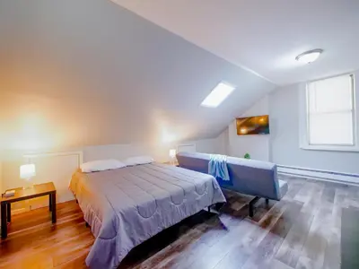 a bedroom with a bed and a table and a window at Cozy Jersey City Apt near NYC Free Wi-Fi & Great Location in Jersey City